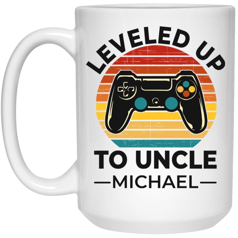 May include: White ceramic mug with a retro-style design featuring a video game controller and the text "LEVELED UP TO UNCLE -MICHAEL-"