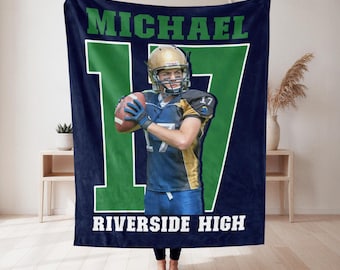 May include: A dark blue fleece blanket featuring a large green number 17 and the text MICHAEL and RIVERSIDE HIGH. The center displays a photographic print of a football player in a blue and gold uniform holding a brown football and wearing a helmet.