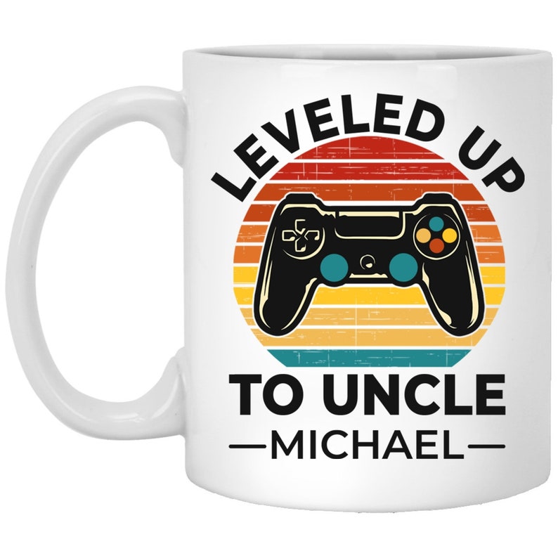 May include: White ceramic mug with a retro-style design featuring a video game controller and the text "LEVELED UP TO UNCLE -MICHAEL-"