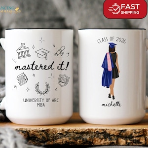Peut inclure: Mug en céramique blanche avec anse et bord noir. Un côté présente des gribouillis sur le thème de la remise des diplômes et le texte "mastered it!" et "UNIVERSITY OF ABC MBA." L'autre côté montre un diplômé et le texte "CLASS OF 2026" et "michelle."