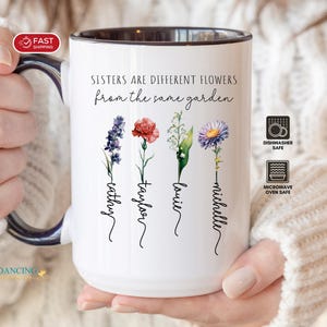 May include: White ceramic mug with a black rim and handle, featuring the text "Sisters are different flowers from the same garden." Floral illustrations and names are printed below. Dishwasher and microwave safe.