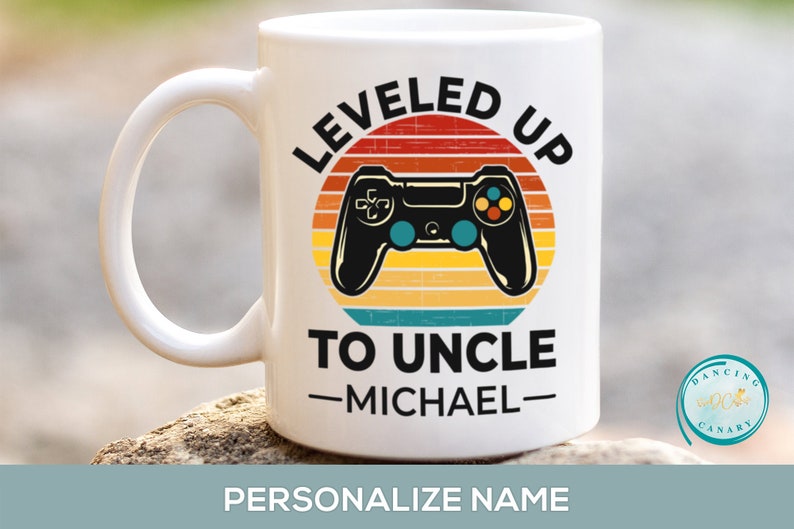 May include: White ceramic coffee mug with a retro-style design featuring a video game controller and the text "LEVELED UP TO UNCLE -MICHAEL-"