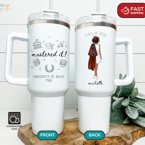 May include: A white ceramic mug with a black handle and the text "But First, Coffee" in a black, bold font. The mug is sitting on a wooden surface. The mug is approximately 4 inches tall.