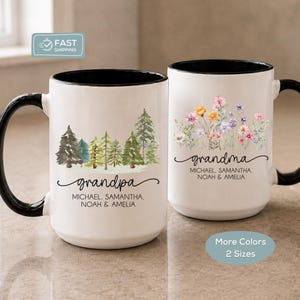 May include: Two white ceramic mugs with black handles and rims. The left mug features a forest graphic with the text "grandpa" and the names "MICHAEL, SAMANTHA, NOAH & AMELIA". The right mug features a wildflower graphic with "grandma" and the same names.
