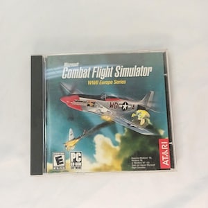 May include: A Microsoft Combat Flight Simulator WWII Europe Series PC CD-ROM game in a clear plastic jewel case. The cover art features a silver fighter plane with a red nose against a blue sky, the Atari logo, and an ESRB Everyone rating symbol.