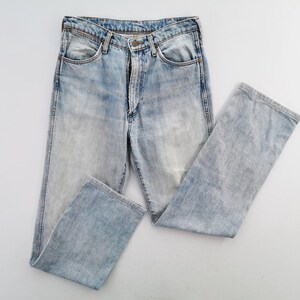 May include: Light blue denim jeans with a faded wash. The jeans have a classic five-pocket design, a button and zipper closure, and a straight leg. The garment is made of cotton and is a size 32 x 30.