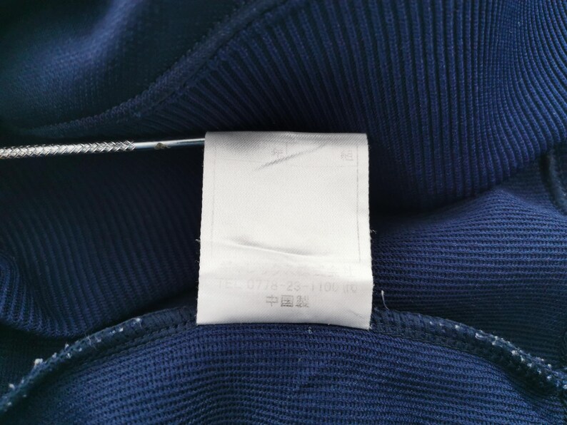 May include: A white ceramic mug with a black handle and the text "But First, Coffee" in a black, bold font. The mug is on a white surface.