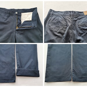 May include: Navy blue pants with a button and zipper closure. The pants have front and back pockets, and the bottom of the pants are cuffed. The pants are made of a durable fabric.
