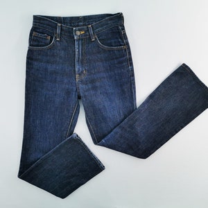 May include: Dark wash denim jeans with a classic five-pocket design. The jeans have a straight leg cut and a button and zipper closure. The jeans are made of a sturdy denim material and are suitable for everyday wear.