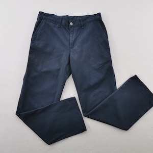 May include: Navy blue pants with a button closure and pockets. The pants are made of a solid, durable fabric and have a classic, straight-leg design. The pants are laid flat on a white surface.