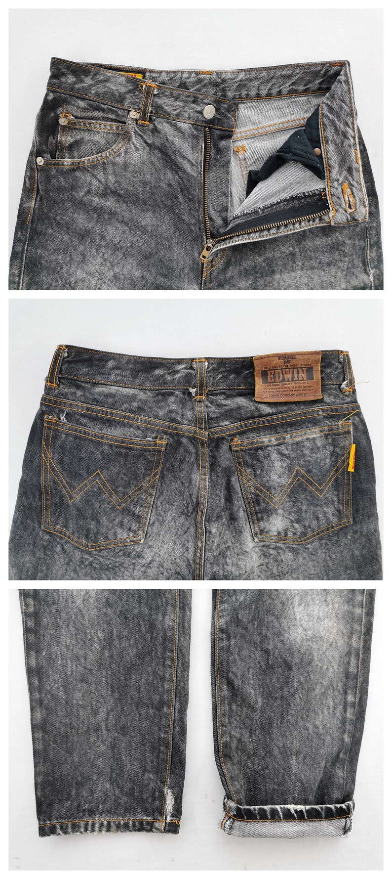 May include: Acid wash denim jeans with a button and zipper closure. The jeans have front and back pockets with orange stitching and a leather "EDWIN" brand patch. The jeans are folded at the bottom.