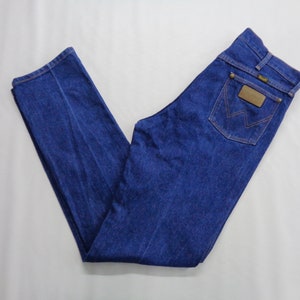 May include: A pair of blue denim jeans with a classic five-pocket design. The jeans feature a brown leather patch on the back pocket with the brand logo. The jeans are made of a durable denim fabric and have a straight leg cut.