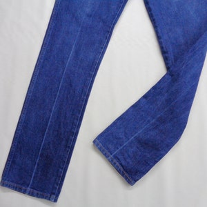 May include: A pair of classic blue denim jeans. The jeans have a straight leg design and are made of a medium-weight denim fabric. The image shows the jeans laid flat, showcasing the front and part of the leg.