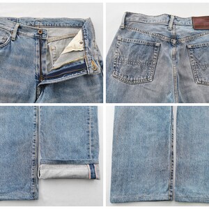 May include: Light blue denim jeans with a classic five-pocket design. The jeans feature a button and zipper closure, belt loops, and a leather patch on the back. The bottom of the jeans are cuffed, revealing a contrasting fabric.