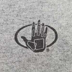 May include: Close-up of a gray t-shirt with a black graphic. The graphic is a hand inside an oval, with the fingers and palm detailed. The t-shirt has a heathered texture.
