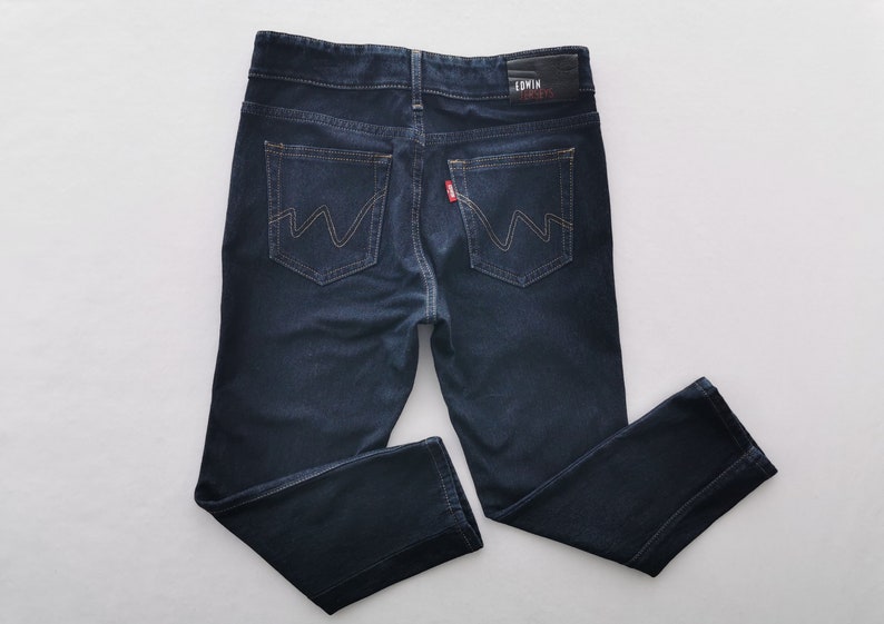 K&ouml;nnte beinhalten: Dunkelblaue Jeans aus Denim mit klassischem F&uuml;nf-Taschen-Design. Mit Lederaufn&auml;her mit Markennamen und rotem Etikett auf der Ges&auml;&szlig;tasche. Die Jeans hat einen geraden Beinverlauf und einen Knopf- und Rei&szlig;verschluss.