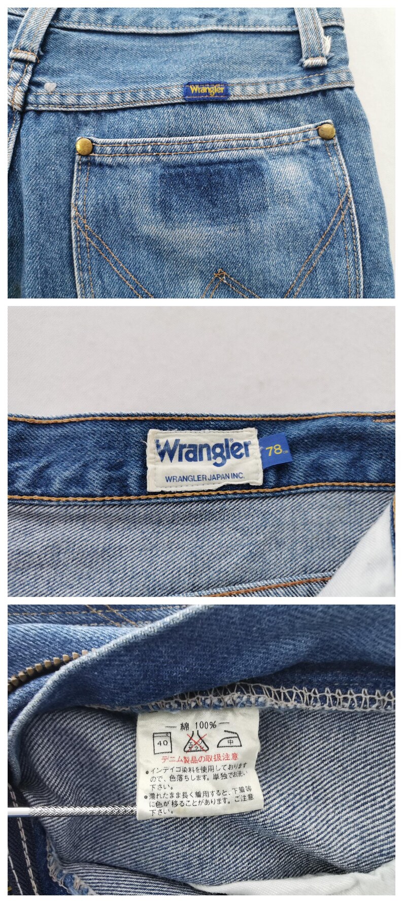 May include: Close-up of blue denim jeans with the Wrangler logo visible on the back pocket and a label. The jeans have a classic design with a button closure and a zipper. The fabric is 100% cotton.