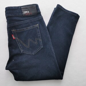 K&ouml;nnte beinhalten: Dunkelblaue Jeans aus Denim mit klassischem F&uuml;nf-Taschen-Design. Mit einem Lederaufn&auml;her mit dem Text "EDWIN" und "JERSEYS" sowie einem roten Logo-Etikett. Die Ges&auml;&szlig;tasche hat ein einzigartiges Nahtdesign.