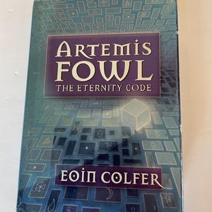 Puede incluir: Una cubierta de libro azul y morado con el título "Artemis Fowl: El Código de la Eternidad" y el nombre del autor "Eoin Colfer".