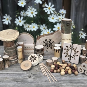 Könnte beinhalten: Ein Set aus Holzspielzeug für Kinder, mit verschiedenen Formen und Größen von Naturholzblöcken mit geometrischen Mustern, die in die Oberfläche gebrannt sind. Das Set enthält auch Holzperlen und -stäbchen.
