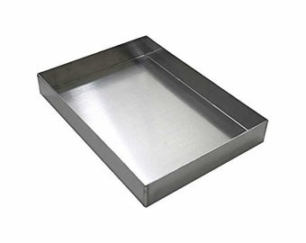 May include: A silver rectangular baking pan with a smooth, shiny surface. The pan is made of metal and has a slightly raised edge.
