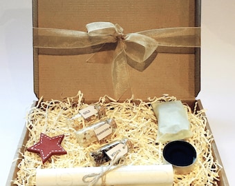 May include: A brown cardboard box filled with shredded paper, containing three small glass bottles with labels that read "Gold", "Frankincense", and "Myrrh", a small red star, a white rolled-up scroll, a small white cloth bag, and a small metal container.