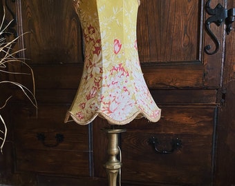 Alte Lampe. Gelber Lampenschirm mit Blumen und altem Messingfuß. altes Französisch.