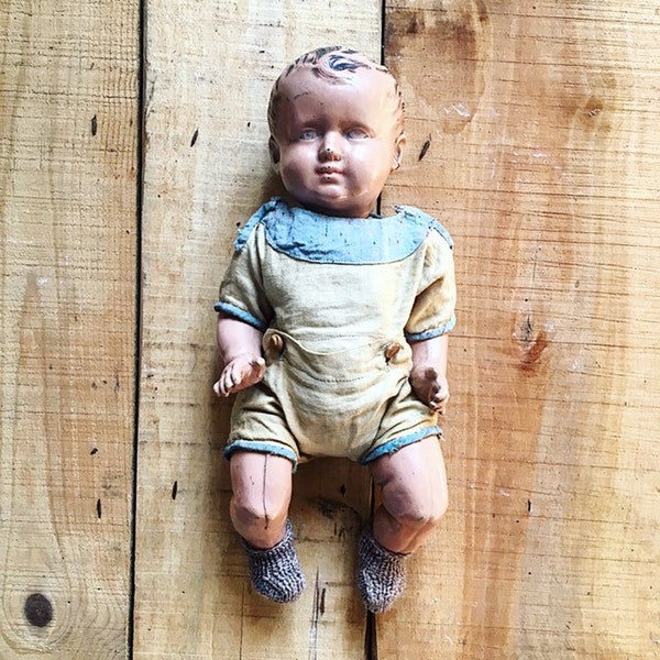 Old brown baby with blue eyes. ancient French. Vintage. Bather