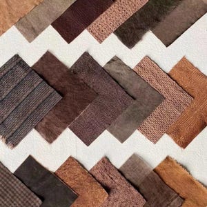 Pode incluir: Uma variedade de amostras de tecido castanho dispostas em padrão zigue-zague sobre um fundo branco. As amostras variam em textura e tonalidade, de liso a texturizado. A paleta de cores varia do bege claro ao chocolate escuro.