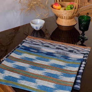 Peut inclure: Un ensemble de quatre sets de table à motifs bleus et bruns. Les sets de table sont en tissu tissé et présentent un motif géométrique. Les sets de table sont empilés les uns sur les autres.