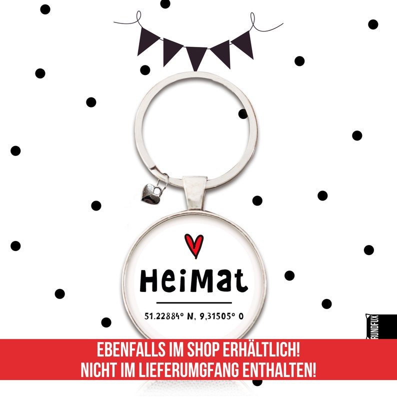 May include: A silver keychain with a round charm that says "Heimat" with a red heart above the word. The charm also includes the coordinates "51.22884&deg; N. 9,31505&deg; 0".