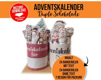 Op de afbeelding: Twee cilindrische adventskalenders met feestelijke illustraties. Eén is rood en de andere is wit. Elke kalender heeft 24 banderollen met tekst en 24 zonder tekst, met 7 verschillende ontwerpen voor de verpakking. De tekst op de kalenders luidt "Adventskalender Duplo Schokolade".