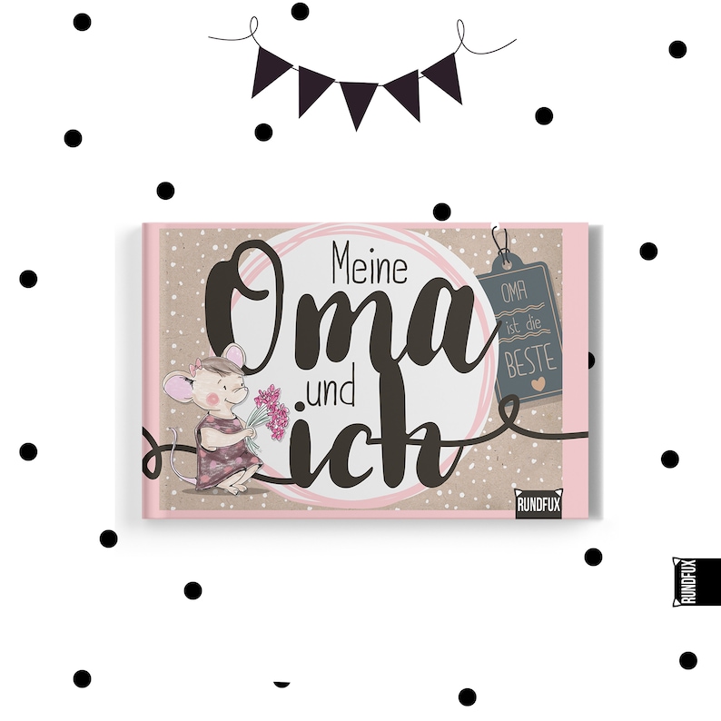 以下が含まれることがあります： 「Meine Oma und ich」のドイツ語テキストが書かれたハードカバーの本。表紙には花を持った漫画のネズミが描かれており、ピンクとベージュの配色です。「Oma ist die Beste」と書かれたタグが付いています。