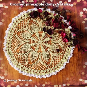 Könnte beinhalten: Eine gehäkelte Ananas-Doyley in hellgrün mit weißem Rand. Die Doyley liegt auf einer Holzoberfläche mit roten Blütenblättern, die um sie herum verstreut sind. Der Text "Crochet pineapple doily-Natalia" und "@Joanna Stawniak" ist auf dem Bild zu sehen.