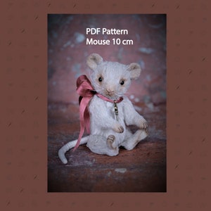 May include: PDF pattern for a white mouse plush toy with a pink bow and a key charm. The mouse is 10 cm tall.