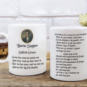 May include: White ceramic mug with a black handle. The mug features a black and white image of Robert Burns and a poem about Burns Supper. The poem includes the text "Burns Supper Selkirk Grace" and "Some hae meat an canna eat, And some wad eat that want it: But we hae meat, and we can eat, And sae the Lord be thankit."