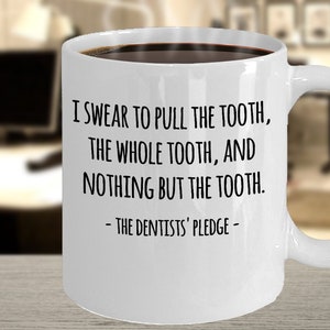 May include: White coffee mug with black text that reads "I swear to pull the tooth, the whole tooth, and nothing but the tooth. - The Dentists' Pledge -"