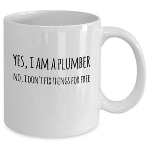 May include: White ceramic coffee mug with black text that reads "YES, I AM A PLUMBER. NO, I DON'T FIX THINGS FOR FREE."