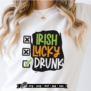 May include: White t-shirt with a black, green, and orange graphic that says "Irish Lucky Drunk" with checkboxes next to each word. The checkbox next to "Drunk" is checked.