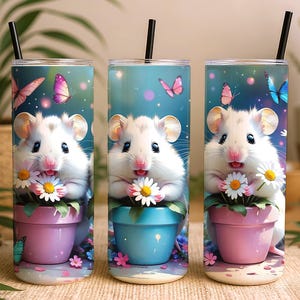 Può includere: Tre bicchieri in acciaio inossidabile con un design stravagante. Ogni bicchiere presenta un simpatico criceto bianco che tiene una margherita in un vaso di fiori, con farfalle e uno sfondo blu. I bicchieri hanno cannucce nere.