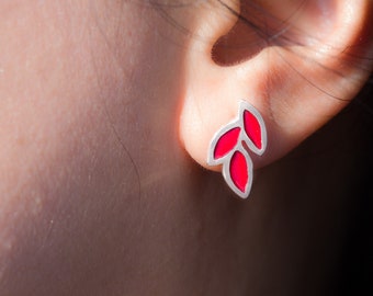 May include: A pair of silver earrings with red enamel leaves. The earrings are small and delicate, and they would make a great gift for a friend or loved one.