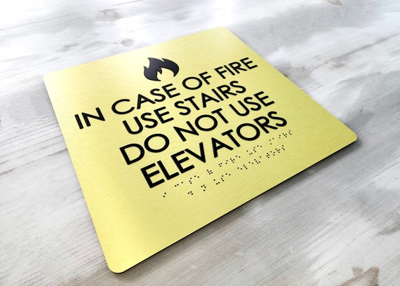 In case of fire use stairs sign. ADA compliant fire emergency signs. ADA building signage. Grade 2 Braille and tactile signs.
