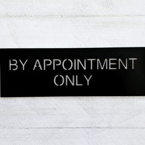 May include: A black sign with white lettering that reads "By Appointment Only".