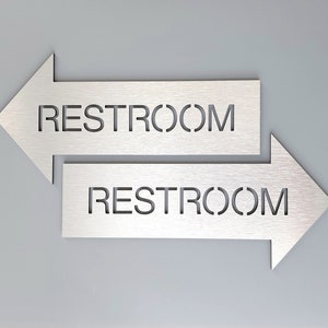 Restroom sign with arrow. Bathroom signs. Wayfinding sign. Information sign. Direction sign. Arrow signs.