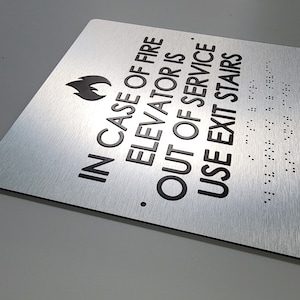In case of fire use stairs ADA sign. Fire emergency signs. Elevator sign. ADA compliant building signs with Grade 2 Braille and raised text.