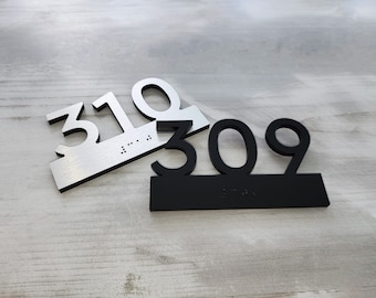 May include: Two house numbers, one silver and one black, with braille lettering. The silver number is 310 and the black number is 309.