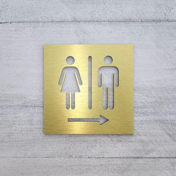 Restroom arrow sign. Bathroom signs with arrow. Directional restroom signs. Informational business sign. Gold. Silver. Black. White.