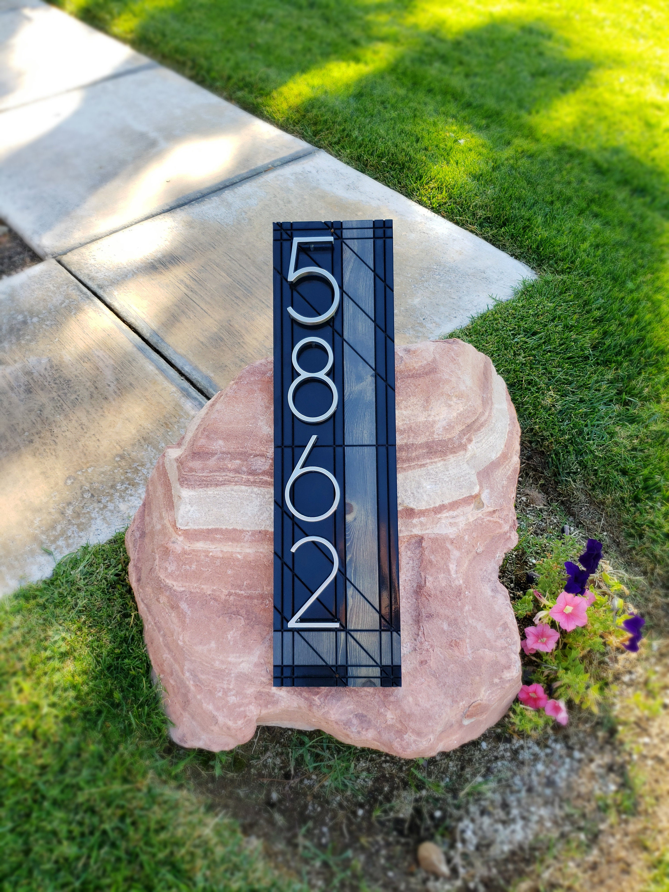 Black house number plaque with silver numbers. Modern address sign.