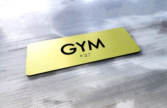 GYM door sign. Gym signs. ADA compliant room identification signs. Custom ADA door signs. Tactile text. Grade 2 Braille sign.