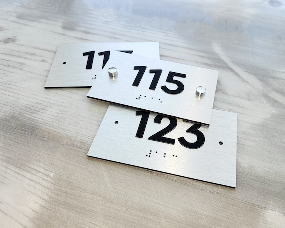 ADA room number signs. Custom ADA compliant number plaques. Apartment numbers with Braille. Tactile hotel room numbers.